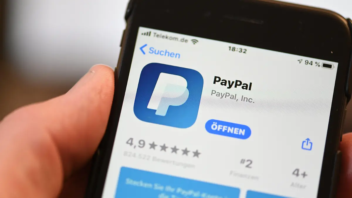 ARCHIV - 29.07.2020, Baden-Württemberg, Ravensburg: Die Applikation von PayPal ist auf einem Mobilfunkgerät zu sehen, das ein Mann in der Hand hält. (zu dpa: "Elterngeld, Paypal, Wahl-O-Mat: Das ändert sich im September") Foto: Felix Kästle/dpa +++ dpa-Bildfunk +++