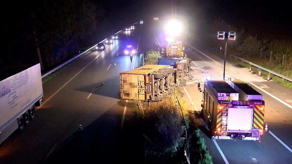 31.08.2021, Niedersachsen, Verden: Ein umgekippter Lastwagen liegt inmitten von zwei Spuren der A27. (zu dpa «Lastwagen kippt bei Unfall auf Gegenfahrbahn - Fahrer eingeklemmt») Foto: --/Nord-West-Media TV/dpa +++ dpa-Bildfunk +++