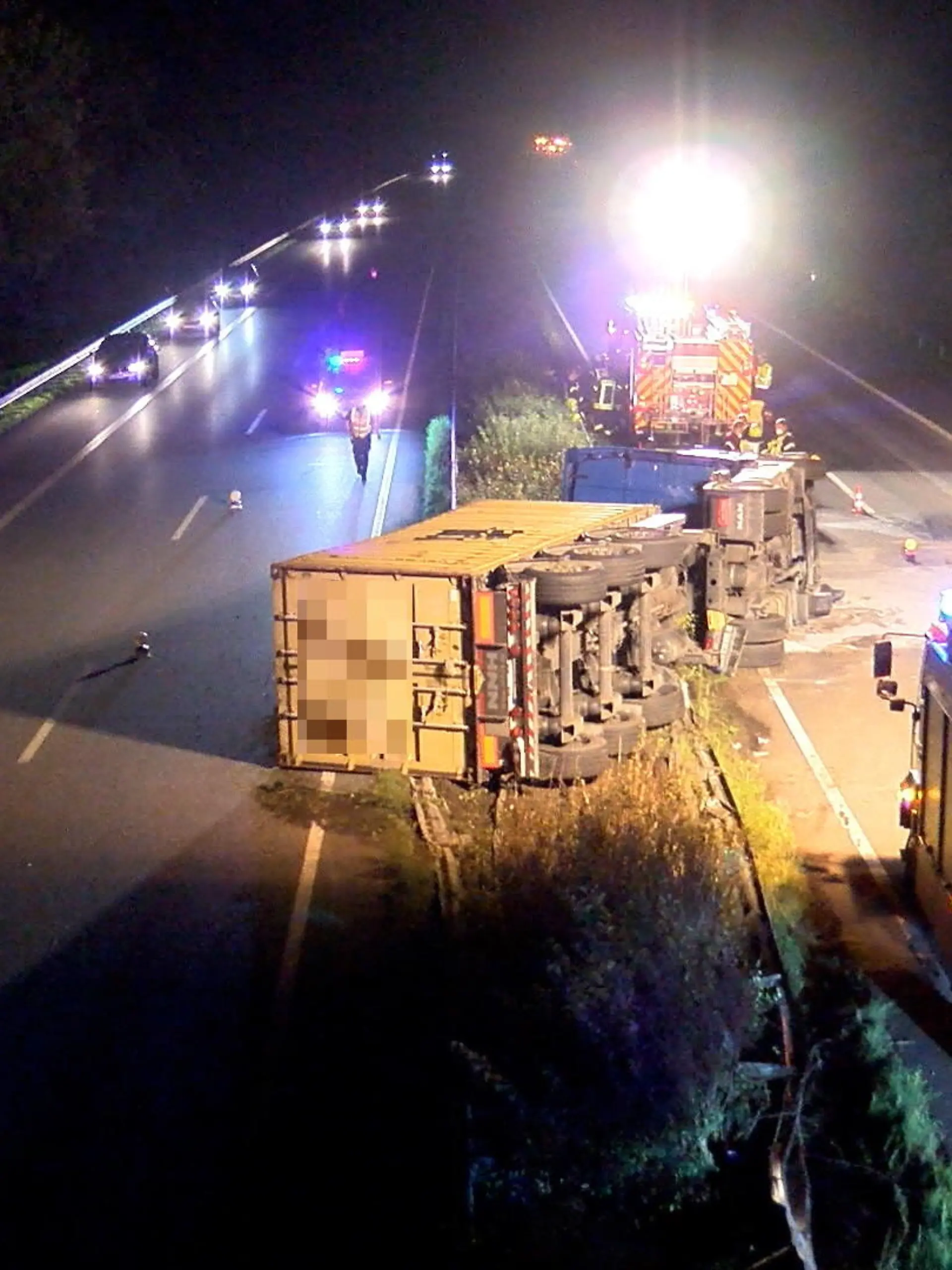 31.08.2021, Niedersachsen, Verden: Ein umgekippter Lastwagen liegt inmitten von zwei Spuren der A27. (zu dpa «Lastwagen kippt bei Unfall auf Gegenfahrbahn - Fahrer eingeklemmt») Foto: --/Nord-West-Media TV/dpa +++ dpa-Bildfunk +++
