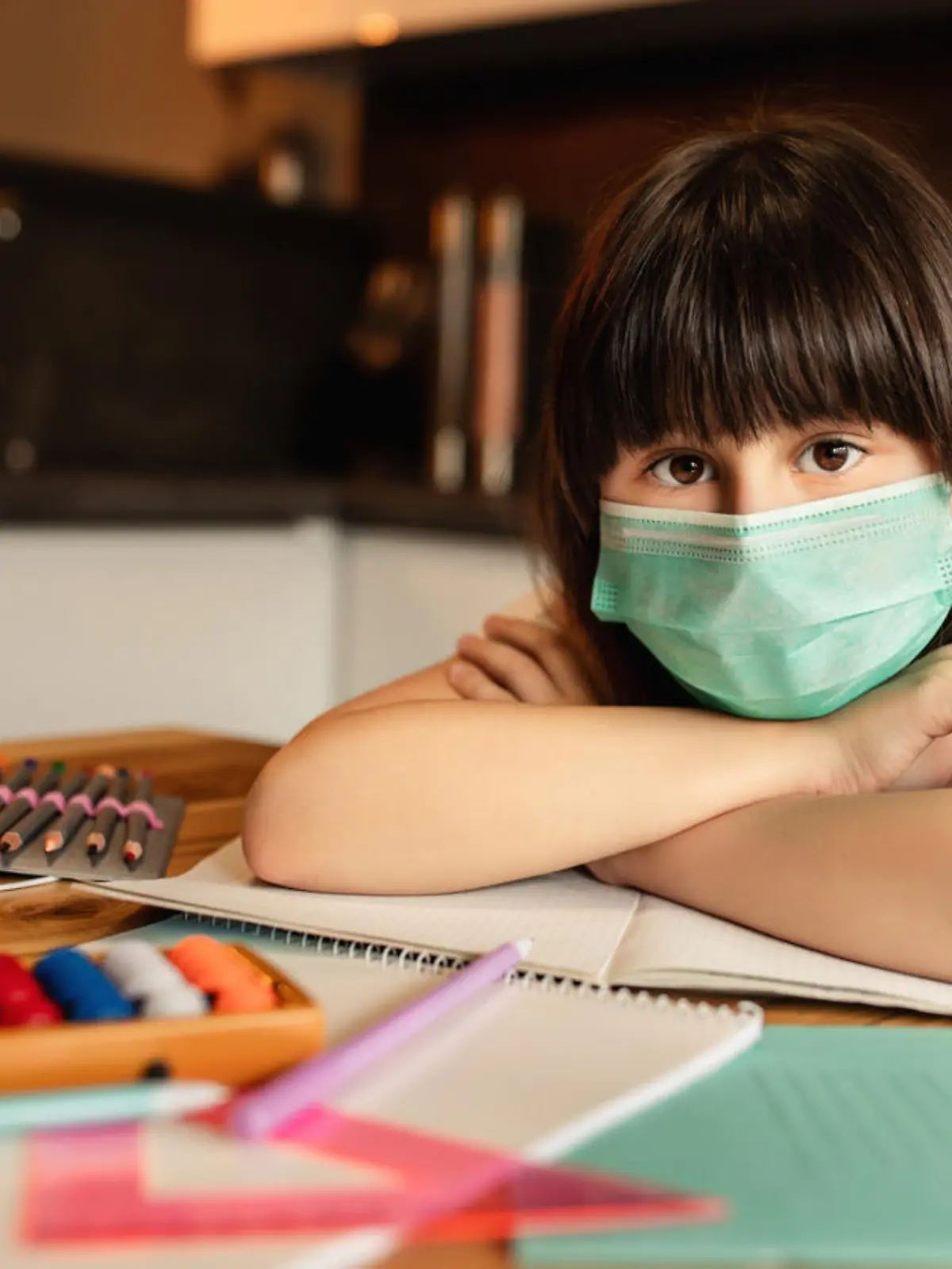 Portrait of girl with protective mask on face at home. Online learning concept
