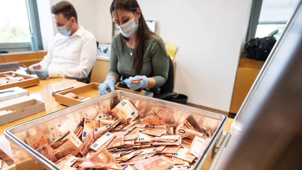 01.09.2021, Rheinland-Pfalz, Mainz: Mitarbeiter der Bundesbank zählen Banknoten, die bei der Flutkatastrophe beschädigt worden waren. Seit der Flutkatastrophe in Rheinland-Pfalz und Nordrhein-Westfalen haben Banken, Geschäftsleute und Privatpersonen bereits mehr als 51 Millionen Euro Bargeld an die Bundesbank geschickt. Das Geld wird den Eigentümern kostenlos ersetzt, die beschädigten Banknoten werden vernichtet. Foto: Boris Roessler/dpa +++ dpa-Bildfunk +++