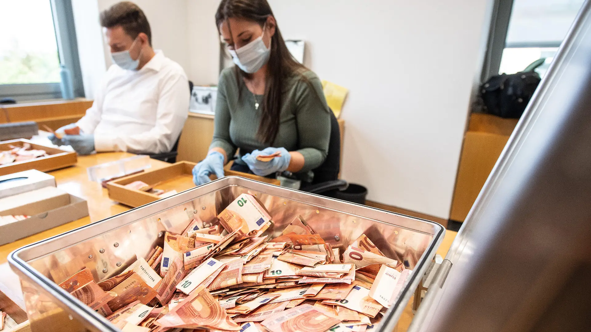 01.09.2021, Rheinland-Pfalz, Mainz: Mitarbeiter der Bundesbank zählen Banknoten, die bei der Flutkatastrophe beschädigt worden waren. Seit der Flutkatastrophe in Rheinland-Pfalz und Nordrhein-Westfalen haben Banken, Geschäftsleute und Privatpersonen bereits mehr als 51 Millionen Euro Bargeld an die Bundesbank geschickt. Das Geld wird den Eigentümern kostenlos ersetzt, die beschädigten Banknoten werden vernichtet. Foto: Boris Roessler/dpa +++ dpa-Bildfunk +++