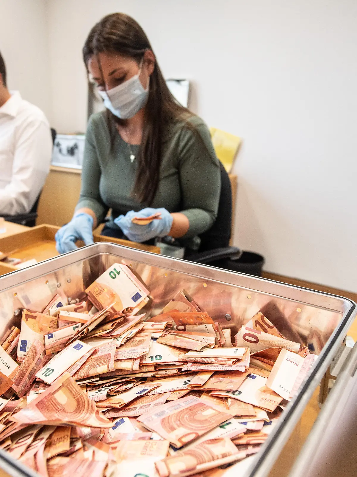 01.09.2021, Rheinland-Pfalz, Mainz: Mitarbeiter der Bundesbank zählen Banknoten, die bei der Flutkatastrophe beschädigt worden waren. Seit der Flutkatastrophe in Rheinland-Pfalz und Nordrhein-Westfalen haben Banken, Geschäftsleute und Privatpersonen bereits mehr als 51 Millionen Euro Bargeld an die Bundesbank geschickt. Das Geld wird den Eigentümern kostenlos ersetzt, die beschädigten Banknoten werden vernichtet. Foto: Boris Roessler/dpa +++ dpa-Bildfunk +++