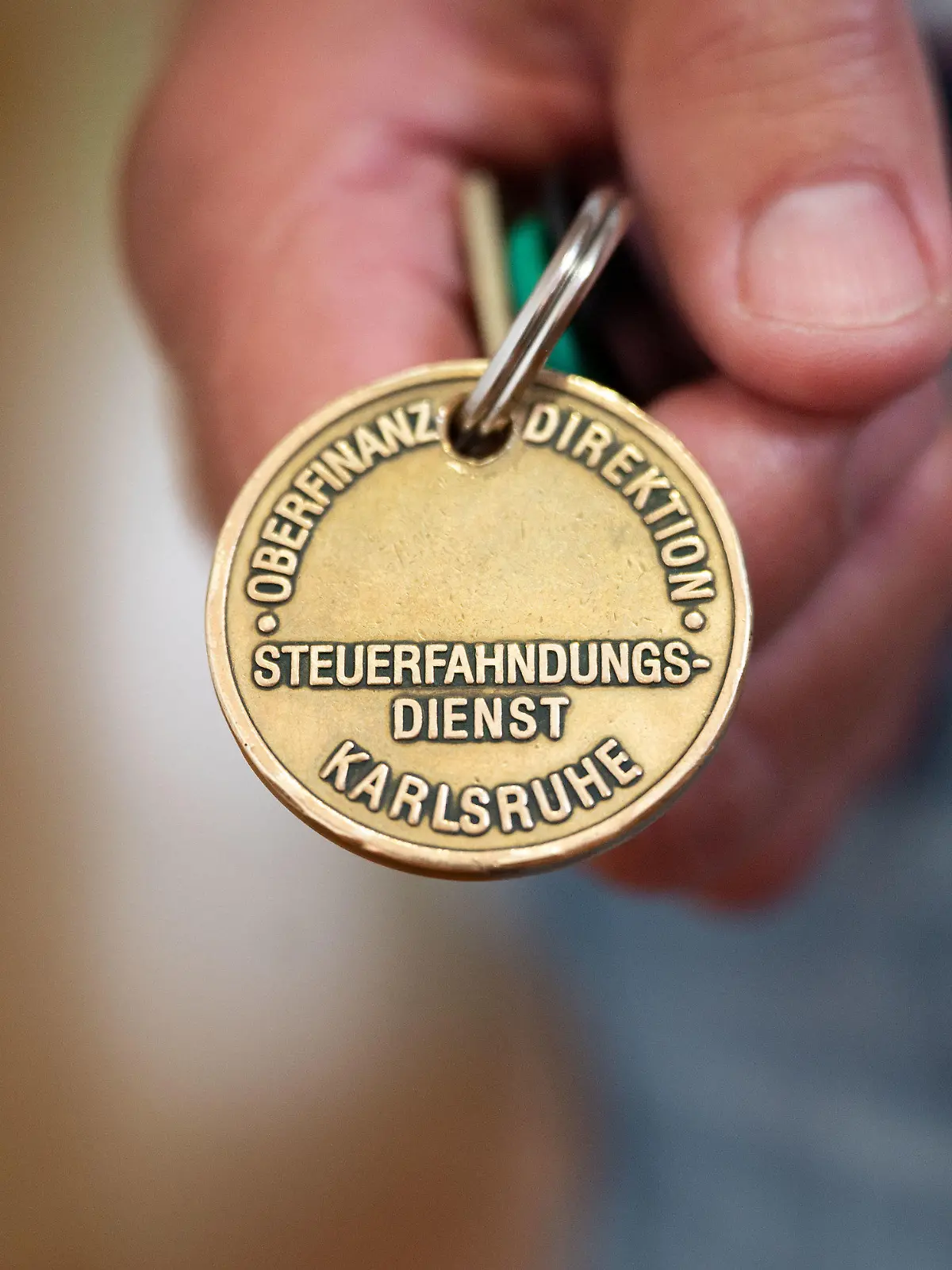 PRODUKTION - 17.08.2021, Baden-Württemberg, Stuttgart: ILLUSTRATION - Ein Steuerfahnder zeigt seine Dienstmarke (gestellte Szene). Die Steuerfahndung prüft verstärkt die Versteuerung von Airbnb-Einnahmen. Foto: Marijan Murat/dpa +++ dpa-Bildfunk +++