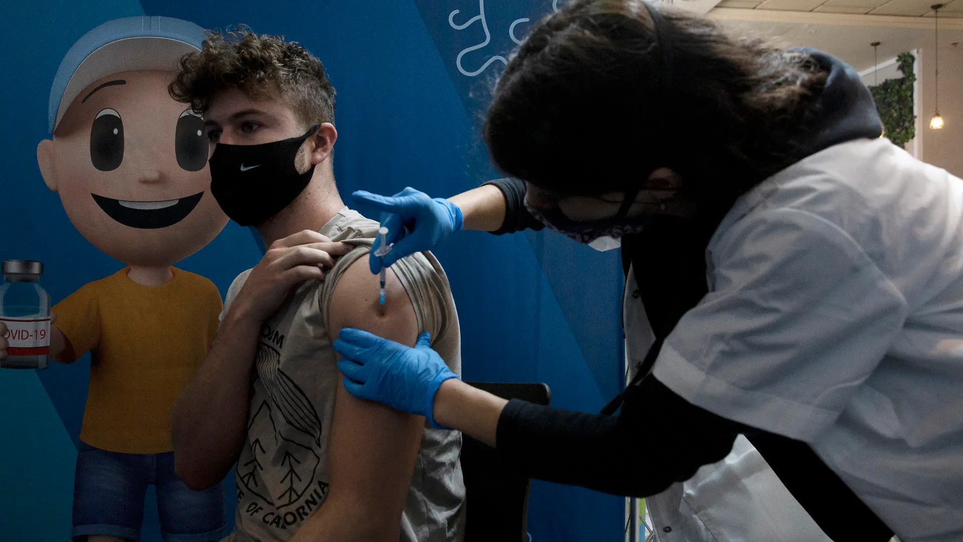 30.08.2021, Israel, Jerusalem: Eine medizinische Angestellte verabreicht einem Mann eine dritte Dosis des Corona-Impfstoffs im Cinema City Komplex. Foto: Maya Alleruzzo/AP/dpa +++ dpa-Bildfunk +++