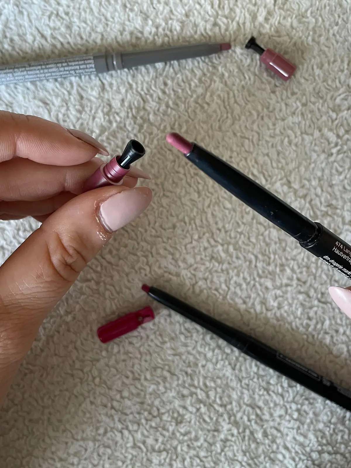 Eine Hand hält einen Lipliner und einen kleinen Anspitzer.