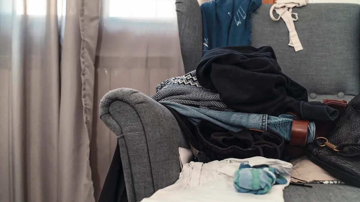 Messy room with scattered clothes on the armchair