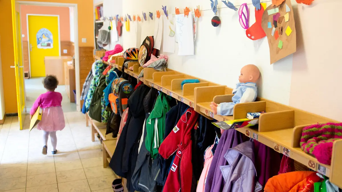 ARCHIV - Ein Mädchen geht am 12.05.2014 in einer Kindertagesstätte in Stuttgart (Baden-Württemberg) an einem Garderobenständer vorbei. Foto: Sebastian Kahnert/dpa (zu dpa/lhe-Umfrage "Werden Kita-Gebühren erstattet?" vom 13.06.2015) +++(c) dpa - Bildfunk+++