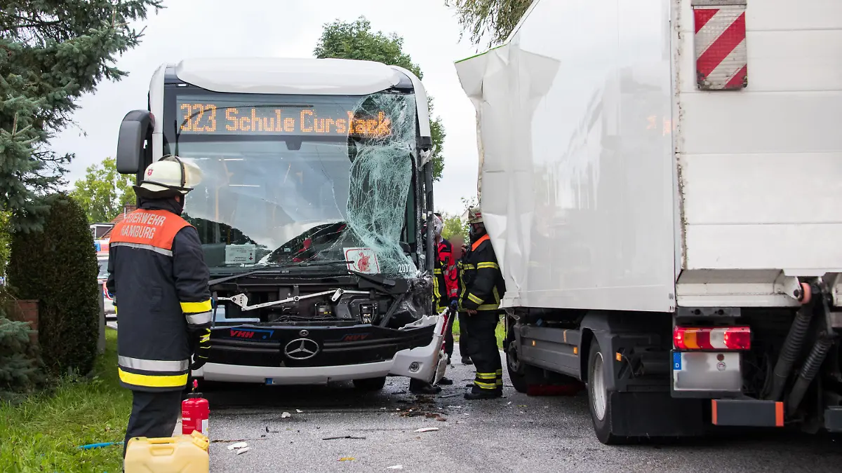 30.08.2021, Hamburg: Einsatzkräfte stehen im Stadtteil Neuengamme an einer Unfallstelle. Bei dem Zusammenstoß zwischen einem Schulbus und einem Lastwagen sind mehrere Schüler verletzt worden. Foto: Daniel Bockwoldt/dpa - ACHTUNG: Eine Person und die Kennzeichen wurden aus rechtlichen Gründen gepixelt +++ dpa-Bildfunk +++