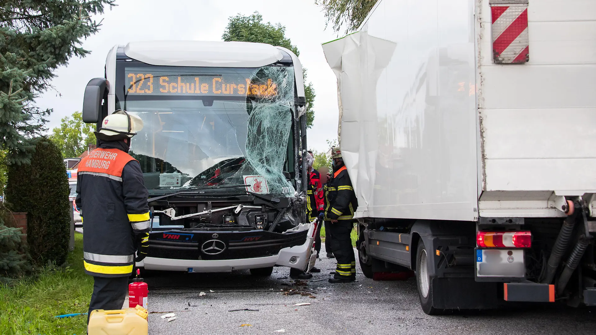 30.08.2021, Hamburg: Einsatzkräfte stehen im Stadtteil Neuengamme an einer Unfallstelle. Bei dem Zusammenstoß zwischen einem Schulbus und einem Lastwagen sind mehrere Schüler verletzt worden. Foto: Daniel Bockwoldt/dpa - ACHTUNG: Eine Person und die Kennzeichen wurden aus rechtlichen Gründen gepixelt +++ dpa-Bildfunk +++