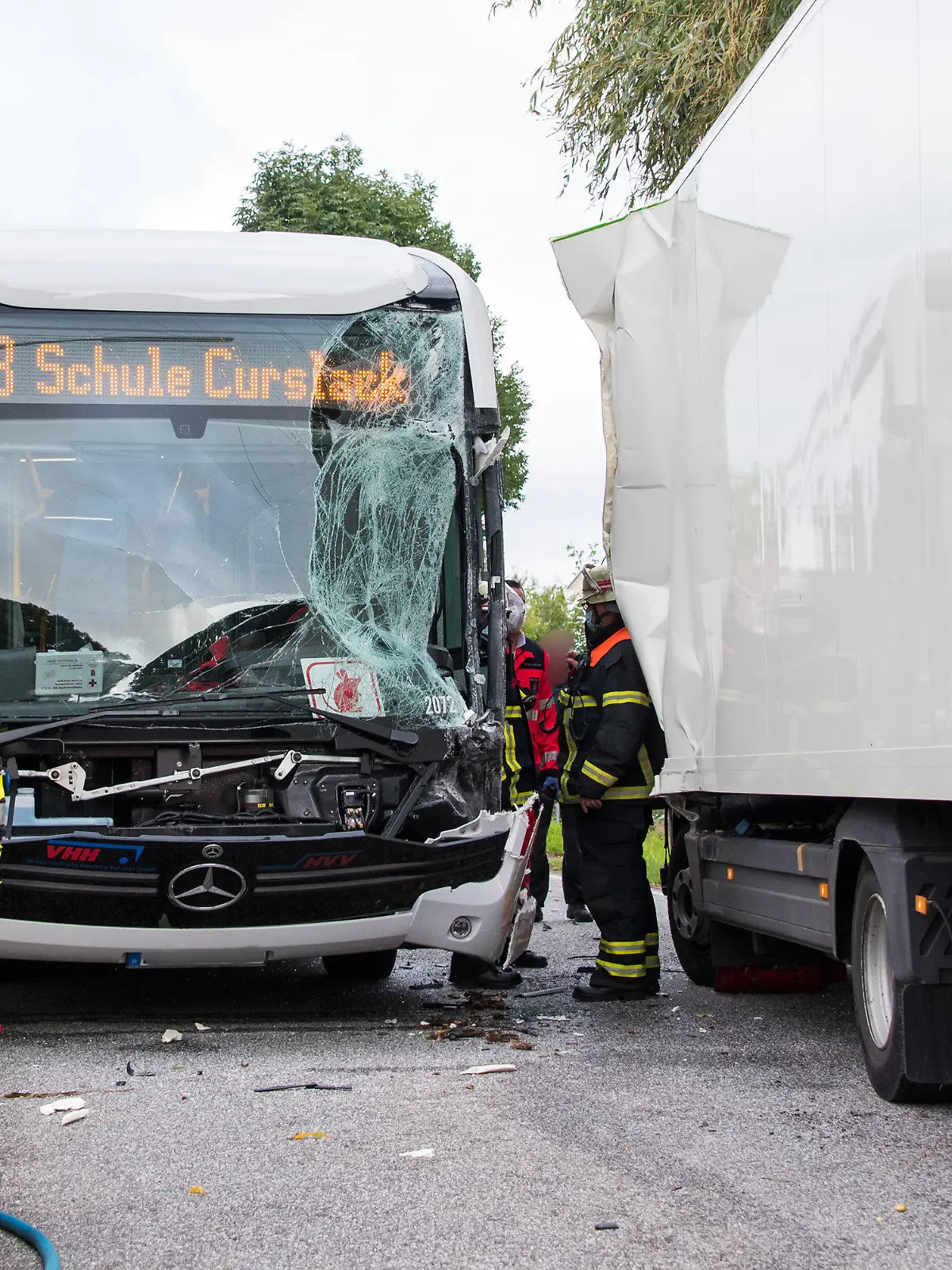 30.08.2021, Hamburg: Einsatzkräfte stehen im Stadtteil Neuengamme an einer Unfallstelle. Bei dem Zusammenstoß zwischen einem Schulbus und einem Lastwagen sind mehrere Schüler verletzt worden. Foto: Daniel Bockwoldt/dpa - ACHTUNG: Eine Person und die Kennzeichen wurden aus rechtlichen Gründen gepixelt +++ dpa-Bildfunk +++