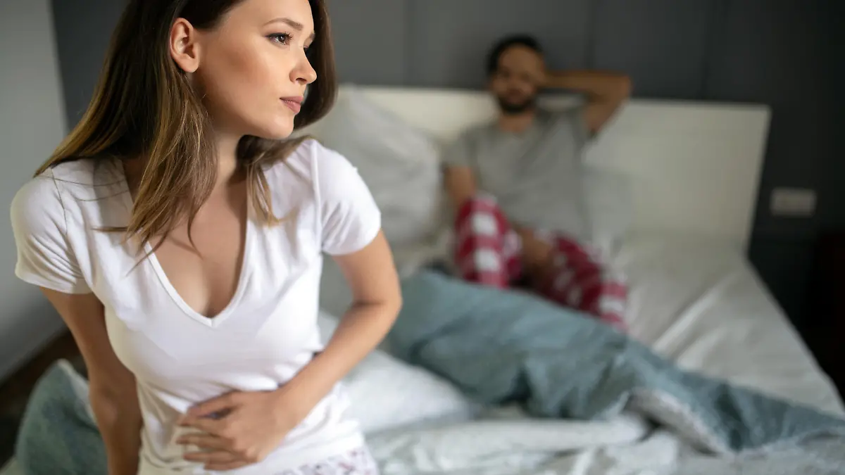 Sad, upset, unhappy woman holding hands on stomach suffering from abdominal pain