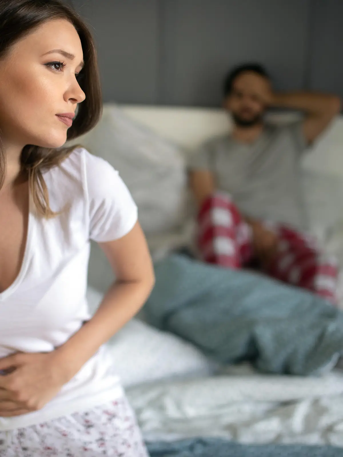 Sad, upset, unhappy woman holding hands on stomach suffering from abdominal pain
