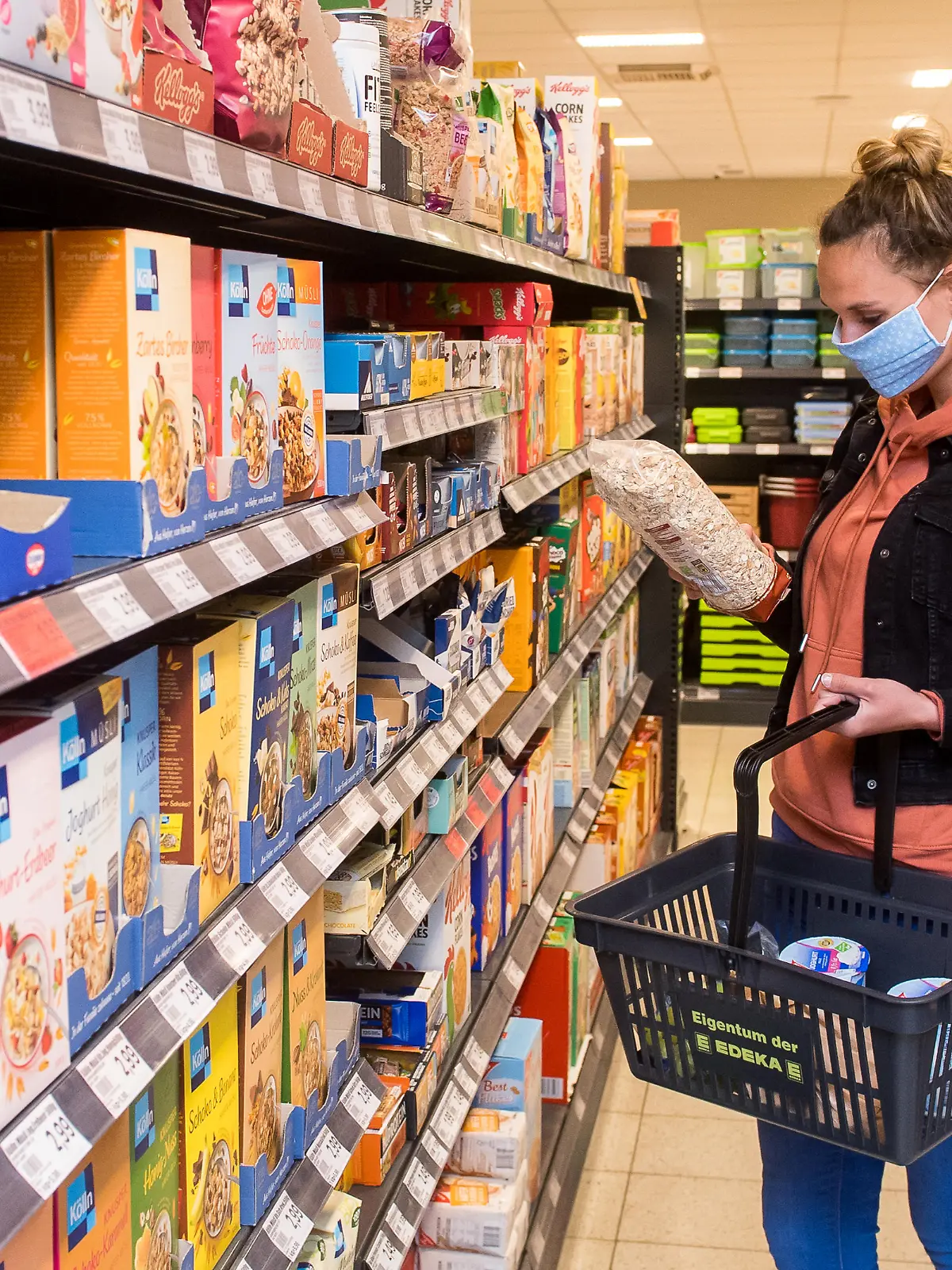 ILLUSTRATION - Eine Frau mit Mundschutz-Maske kauft am 29.04.2020 in Flensburg in einem Supermarkt ein (gestellte Szene). Foto: Benjamin Nolte || Modellfreigabe vorhanden