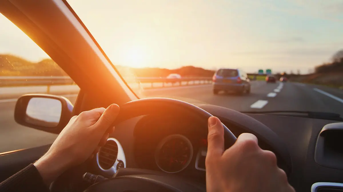 hands of car driver on steering wheel, road trip, driving on highway road