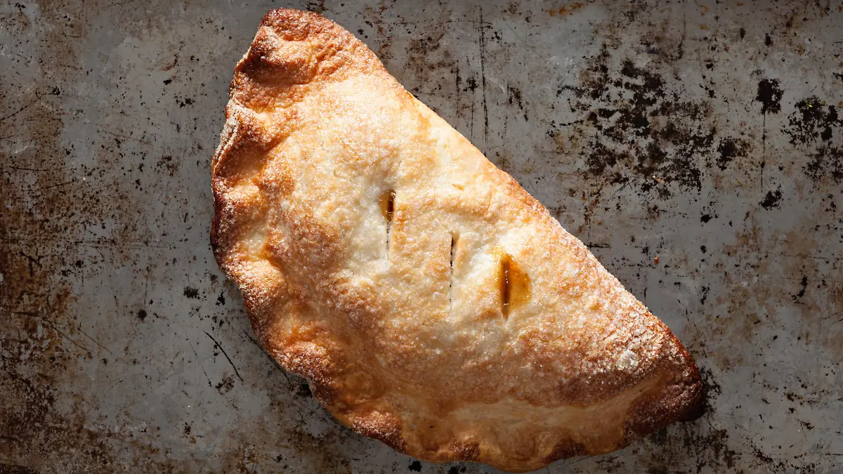 An overhead close up shot of a freshly baked apple hand pie or turnover