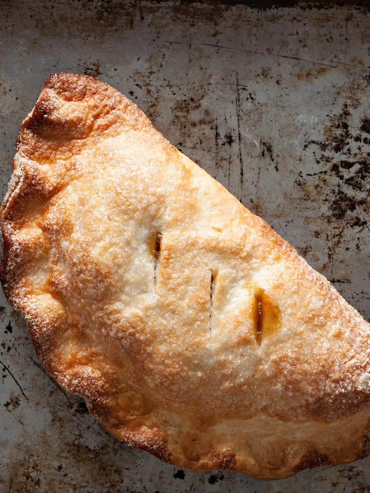 An overhead close up shot of a freshly baked apple hand pie or turnover