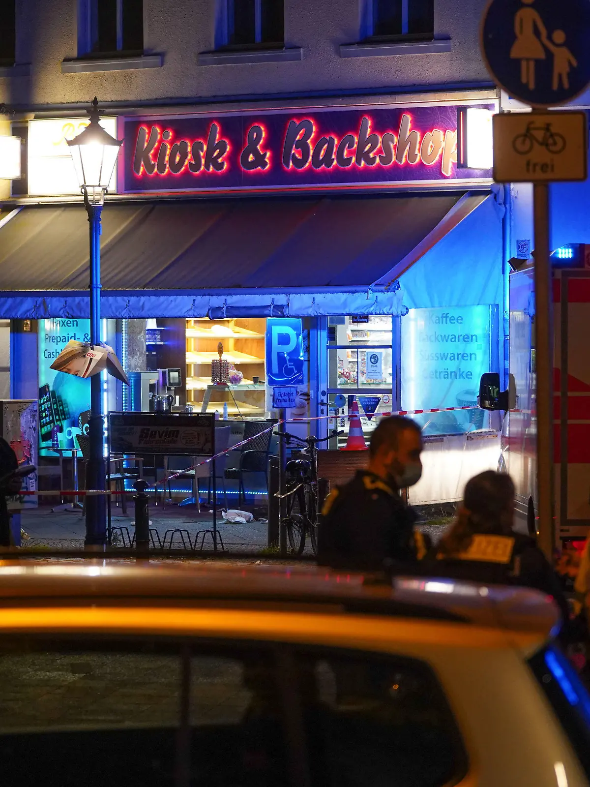 27.08.2021, Berlin: Einsatzkräfte der Polizei stehen vor einem Kiosk in der Reinickendorfer Straße. Nach mehreren Schüssen in Berlin-Wedding ist ein Mann gestorben. Foto: Jörg Carstensen/dpa +++ dpa-Bildfunk +++