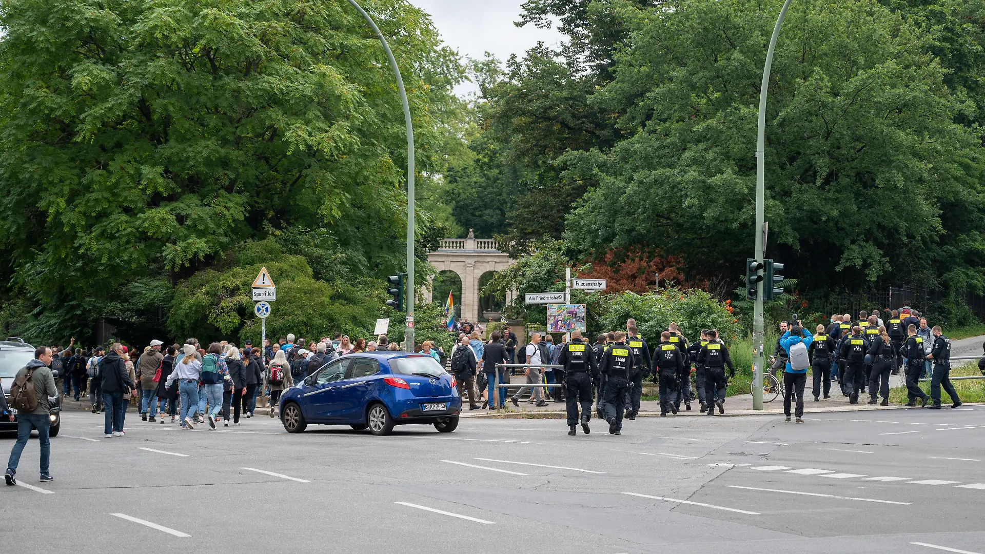 28.08.2021, Berlin: Polizisten begleiten Demonstranten, die sich aus Protest gegen die Corona-Politik vor dem Märchenbrunnen in Berlin-Friedrichshain versammeln. Neun Demonstrationen waren von der Polizei verboten worden, darunter Kundgebungen der «Initiative Querdenken» auf der Straße des 17. Juni. Eine für Samstag und Sonntag angemeldete Versammlung mit je 500 erwarteten Teilnehmern darf nun doch stattfinden. Foto: Christophe Gateau/dpa +++ dpa-Bildfunk +++