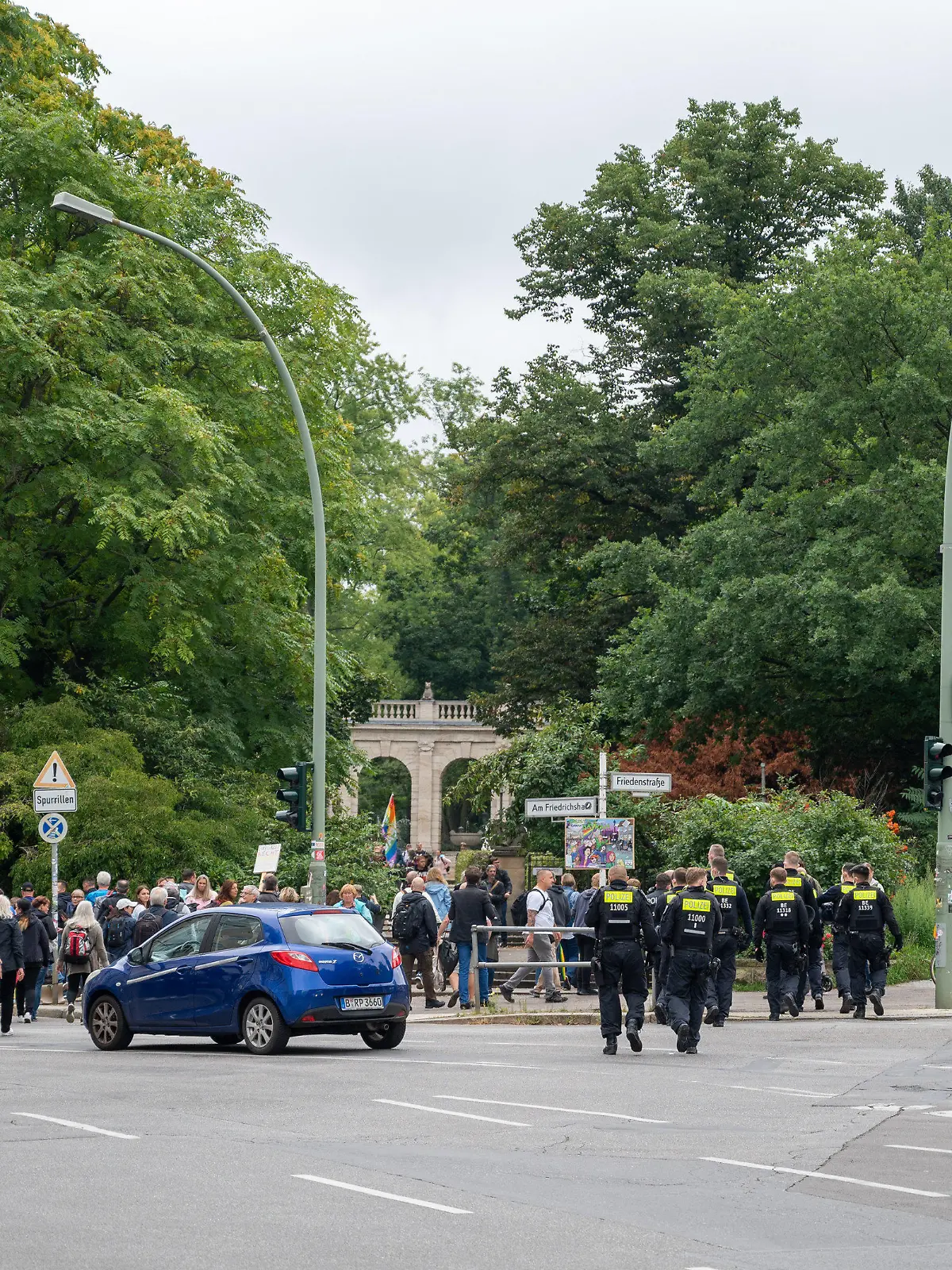 28.08.2021, Berlin: Polizisten begleiten Demonstranten, die sich aus Protest gegen die Corona-Politik vor dem Märchenbrunnen in Berlin-Friedrichshain versammeln. Neun Demonstrationen waren von der Polizei verboten worden, darunter Kundgebungen der «Initiative Querdenken» auf der Straße des 17. Juni. Eine für Samstag und Sonntag angemeldete Versammlung mit je 500 erwarteten Teilnehmern darf nun doch stattfinden. Foto: Christophe Gateau/dpa +++ dpa-Bildfunk +++