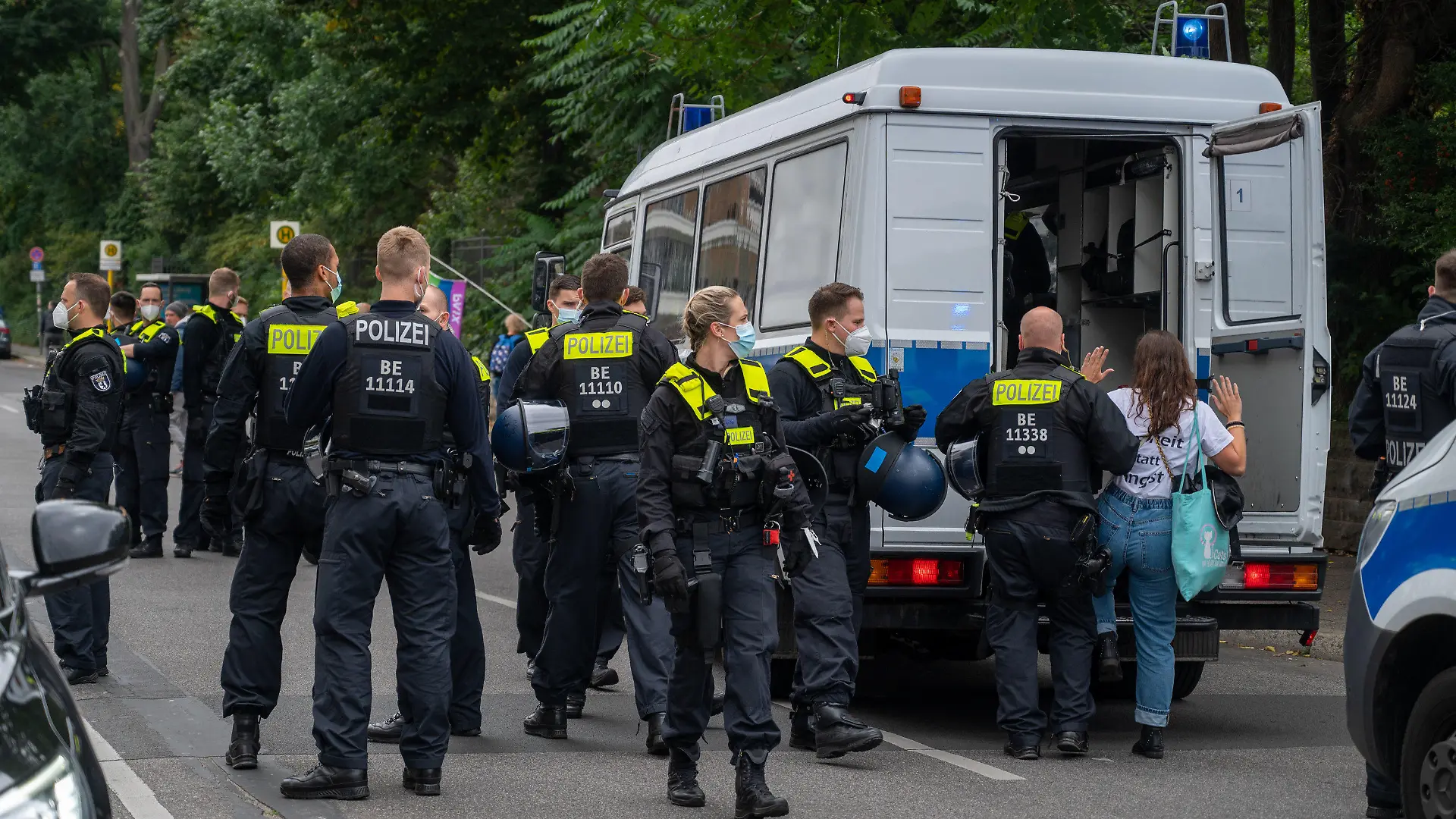 28.08.2021, Berlin: Ein Polizist führt eine Demonstrantin in einen Polizeiwagen, während sich Demonstranten aus Protest gegen die Corona-Politik vor dem Märchenbrunnen in Berlin-Friedrichshain versammeln. Neun Demonstrationen waren von der Polizei verboten worden, darunter Kundgebungen der «Initiative Querdenken» auf der Straße des 17. Juni. Eine für Samstag und Sonntag angemeldete Versammlung mit je 500 erwarteten Teilnehmern darf nun doch stattfinden. Foto: Christophe Gateau/dpa +++ dpa-Bildfunk +++