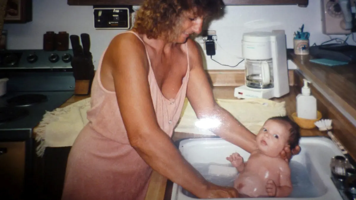 PIC FROM Kennedy News and Media (PICTURED: JESS KAUFMAN, 30, FROM KANSAS, US, AS A BABY WITH HER MUM, SHOWING HER ABDOMINAL SCAR) A woman born who was branded an 'alien' while growing up for being born without a BELLY BUTTON and even got a stomach piercing just to 'fit in' now proudly embraces her 'uniqueness' by wearing crop tops. Jess Kaufman, from Kansas, US, was born with an omphalocele - a rare birth defect where some of a baby's organs develop outside of the abdominal wall during pregnancy and so have to be put back inside at birth. Since the 30-year-old's umbilical cord wasn't cut externally as normally happens at birth, she was left without a belly button, leading her to face heartless name-calling growing up - with some not even believing it was possible. DISCLAIMER: While Kennedy News and Media uses its best endeavours to establish the copyright and authenticity of all pictures supplied, it accepts no liability for any damage, loss or legal action caused by the use of images supplied and the publication of images is solely at your discretion. SEE KENNEDY NEWS COPY - 0161 697 4266