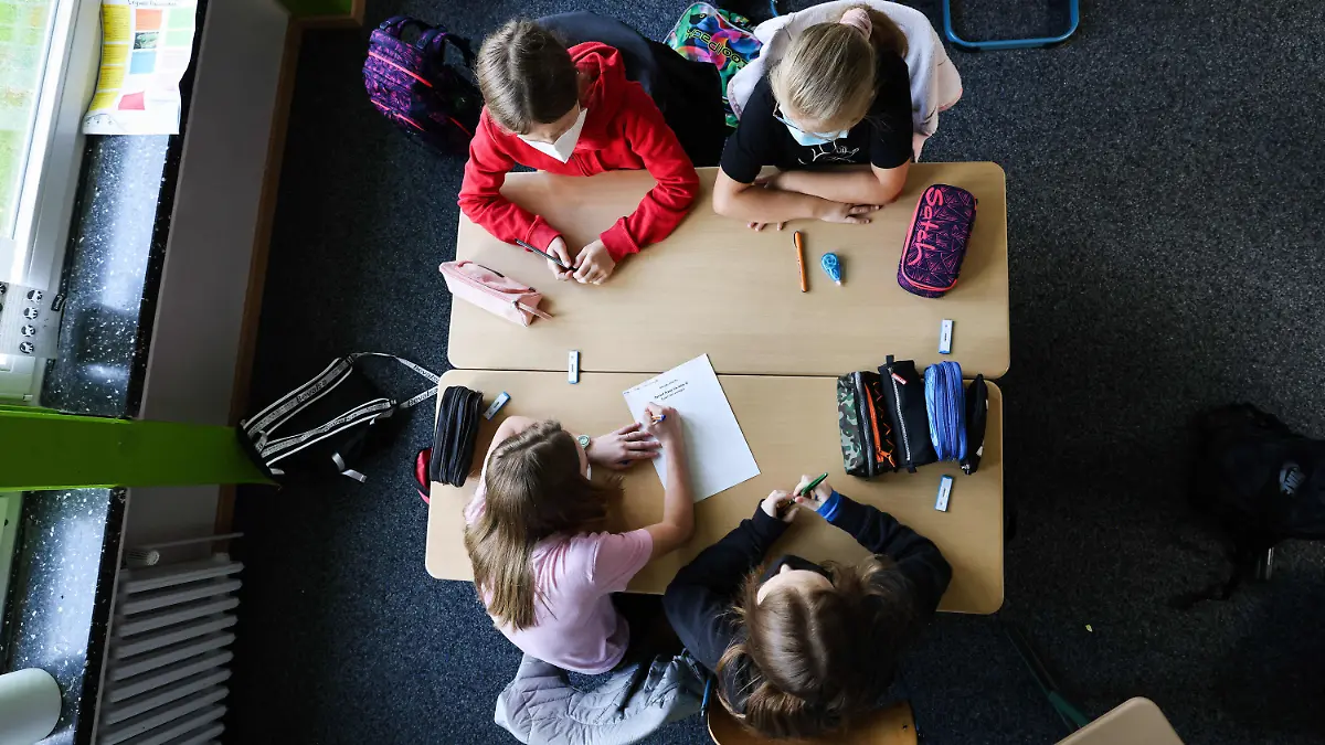 ARCHIV - 05.08.2021, Hamburg: Schülerinnen und Schüler der Klasse 6a am Goethe-Gymnasium in Hamburg-Lurup schreiben in einer Gruppenarbeit im Klassenzimmer ihre Wünsche für das neue Schuljahr auf einen Zettel unter dem Motto: «Darauf freue ich mich?» am ersten Schultag nach den Ferien. In immer mehr Bundesländern gehen die Ferien zu Ende, die Schulen starten mit Präsenzunterricht. Wie lange kann das in der Pandemie mit der inzwischen vorherrschenden Delta-Variante gut gehen? (zu dpa «Schulstart mit Delta-Variante - geht das gut?») Foto: Christian Charisius/dpa +++ dpa-Bildfunk +++