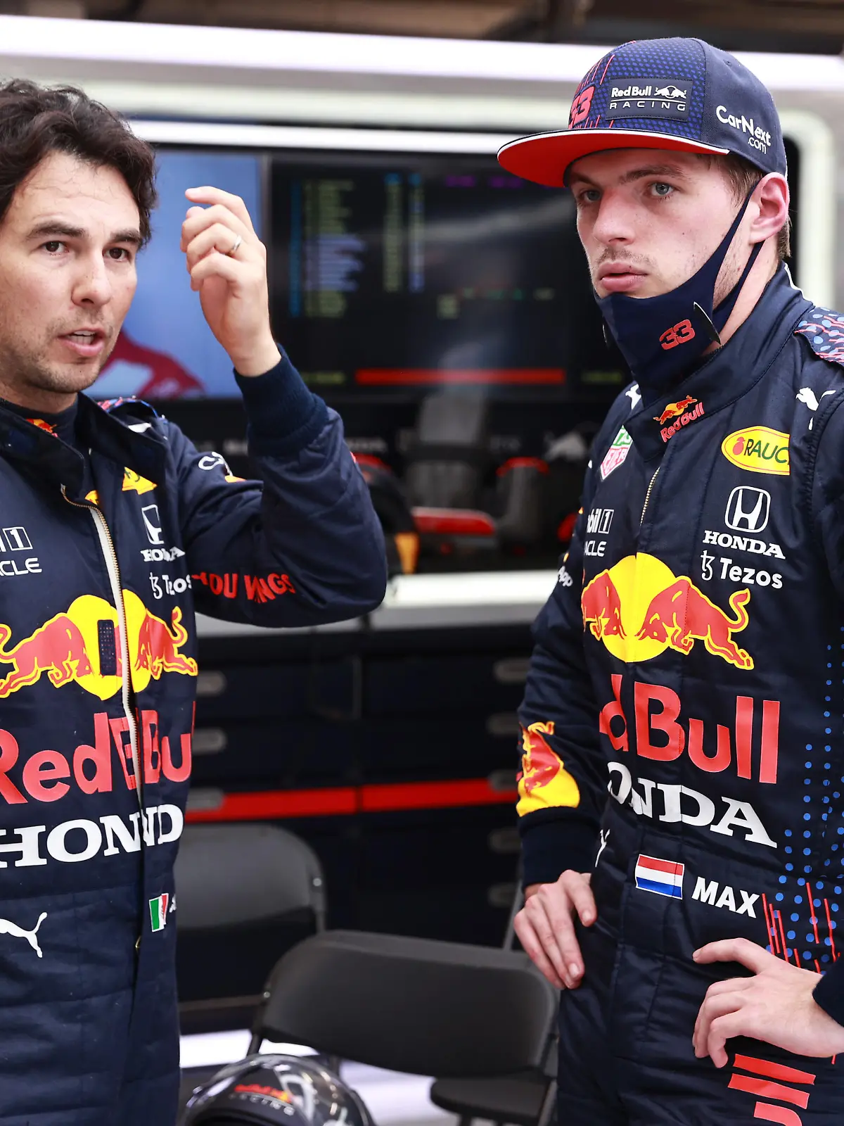 BUDAPEST, HUNGARY - AUGUST 01: Max Verstappen of Netherlands and Red Bull Racing and Sergio Perez of Mexico and Red Bull Racing talk in the garage during the red flag delay during the F1 Grand Prix of Hungary at Hungaroring on August 01, 2021 in Budapest, Hungary. (Photo by Mark Thompson/Getty Images)