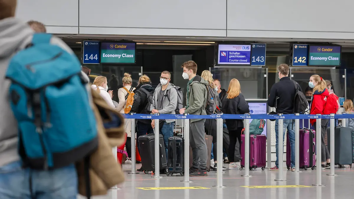 Düsseldorf, Nordrhein-Westfalen, Deutschland - Flughafen Düsseldorf, Osterurlauber am Condor Check-in Schalter in Zeiten der Coronapandemie auf dem Weg nach Mallorca, vor dem Flug nach Spanien und auch vor dem Rückflug nach Deutschland müssen Flugreisende einen negativen Coronatest vorweisen. Düsseldorf Nordrhein-Westfalen Deutschland *** Düsseldorf, North Rhine Westphalia, Germany Düsseldorf Airport, Easter holidaymakers at the Condor check in counter in times of the corona pandemic on the way to Mallorca, before the flight to Spain and also before the return flight to Germany, air travellers must show a negative corona test Düsseldorf North Rhine Westphalia Germany 