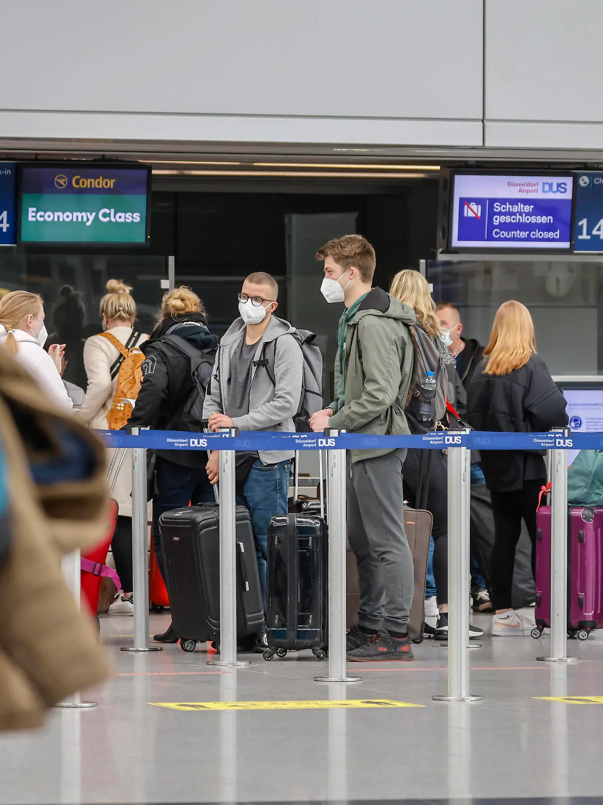 Düsseldorf, Nordrhein-Westfalen, Deutschland - Flughafen Düsseldorf, Osterurlauber am Condor Check-in Schalter in Zeiten der Coronapandemie auf dem Weg nach Mallorca, vor dem Flug nach Spanien und auch vor dem Rückflug nach Deutschland müssen Flugreisende einen negativen Coronatest vorweisen. Düsseldorf Nordrhein-Westfalen Deutschland *** Düsseldorf, North Rhine Westphalia, Germany Düsseldorf Airport, Easter holidaymakers at the Condor check in counter in times of the corona pandemic on the way to Mallorca, before the flight to Spain and also before the return flight to Germany, air travellers must show a negative corona test Düsseldorf North Rhine Westphalia Germany 