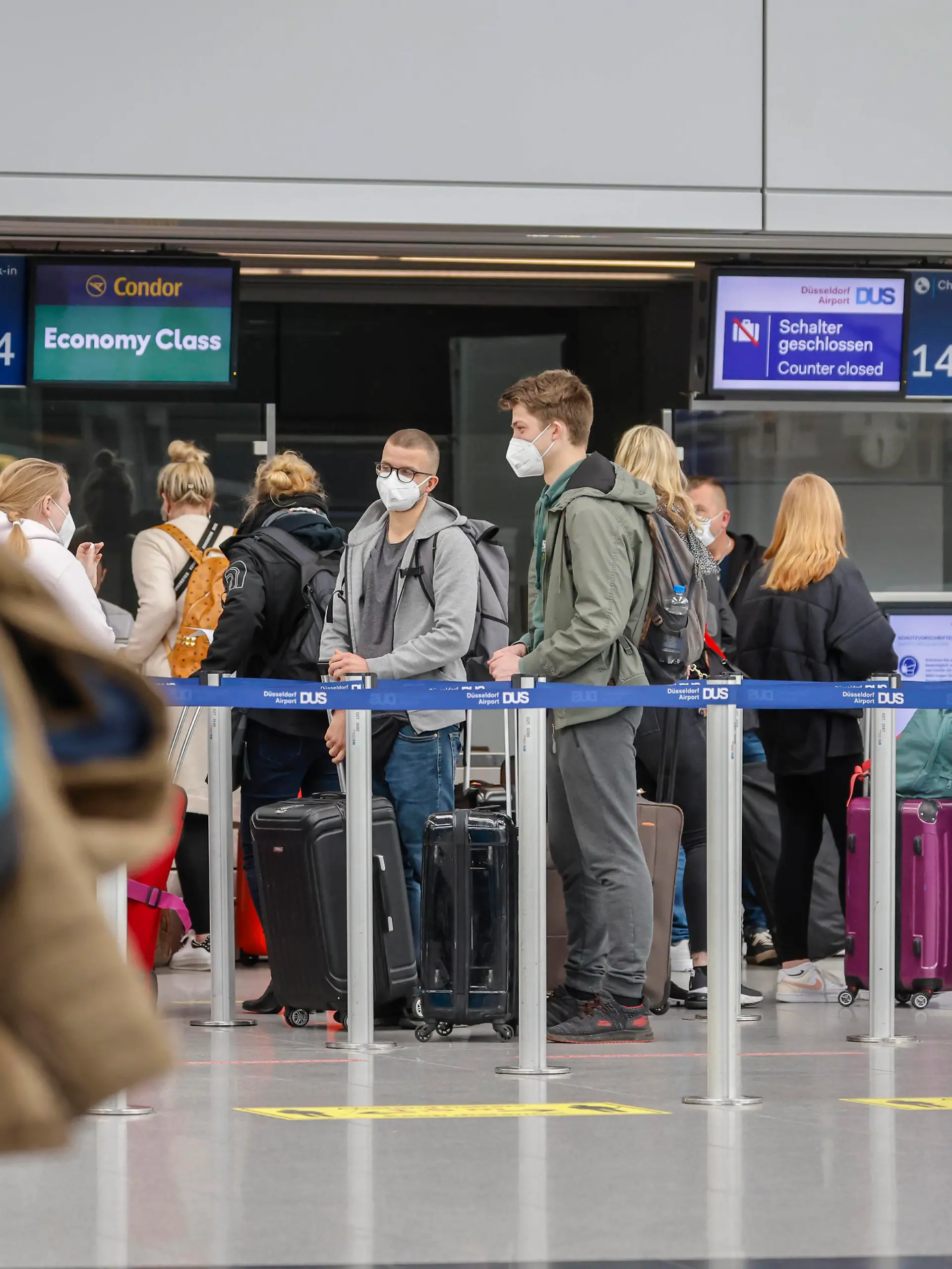 Düsseldorf, Nordrhein-Westfalen, Deutschland - Flughafen Düsseldorf, Osterurlauber am Condor Check-in Schalter in Zeiten der Coronapandemie auf dem Weg nach Mallorca, vor dem Flug nach Spanien und auch vor dem Rückflug nach Deutschland müssen Flugreisende einen negativen Coronatest vorweisen. Düsseldorf Nordrhein-Westfalen Deutschland *** Düsseldorf, North Rhine Westphalia, Germany Düsseldorf Airport, Easter holidaymakers at the Condor check in counter in times of the corona pandemic on the way to Mallorca, before the flight to Spain and also before the return flight to Germany, air travellers must show a negative corona test Düsseldorf North Rhine Westphalia Germany 