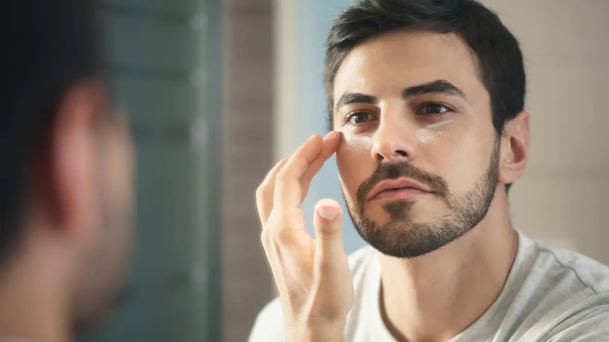 Mann trägt Make-up im Gesicht auf.