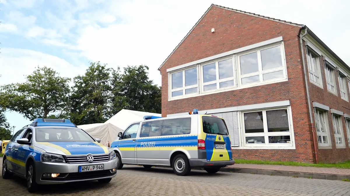 26.08.2021, Niedersachsen, Schortens: Polizeiwagen stehen vor dem Impfzentrum. In den Morgenstunden durchsuchten Beamte mehrere Gebäude des Deutschen Roten Kreuzes (DRK) in Friesland. Die Soko "Vakzin" hat bei ihren Ermittlungen weitere Unregelmäßigkeiten festgestellt.      (zu dpa "Durchsuchungen bei Ermittlungen zu Kochsalz-Injektionen") Foto: Markus Hibbeler/dpa +++ dpa-Bildfunk +++