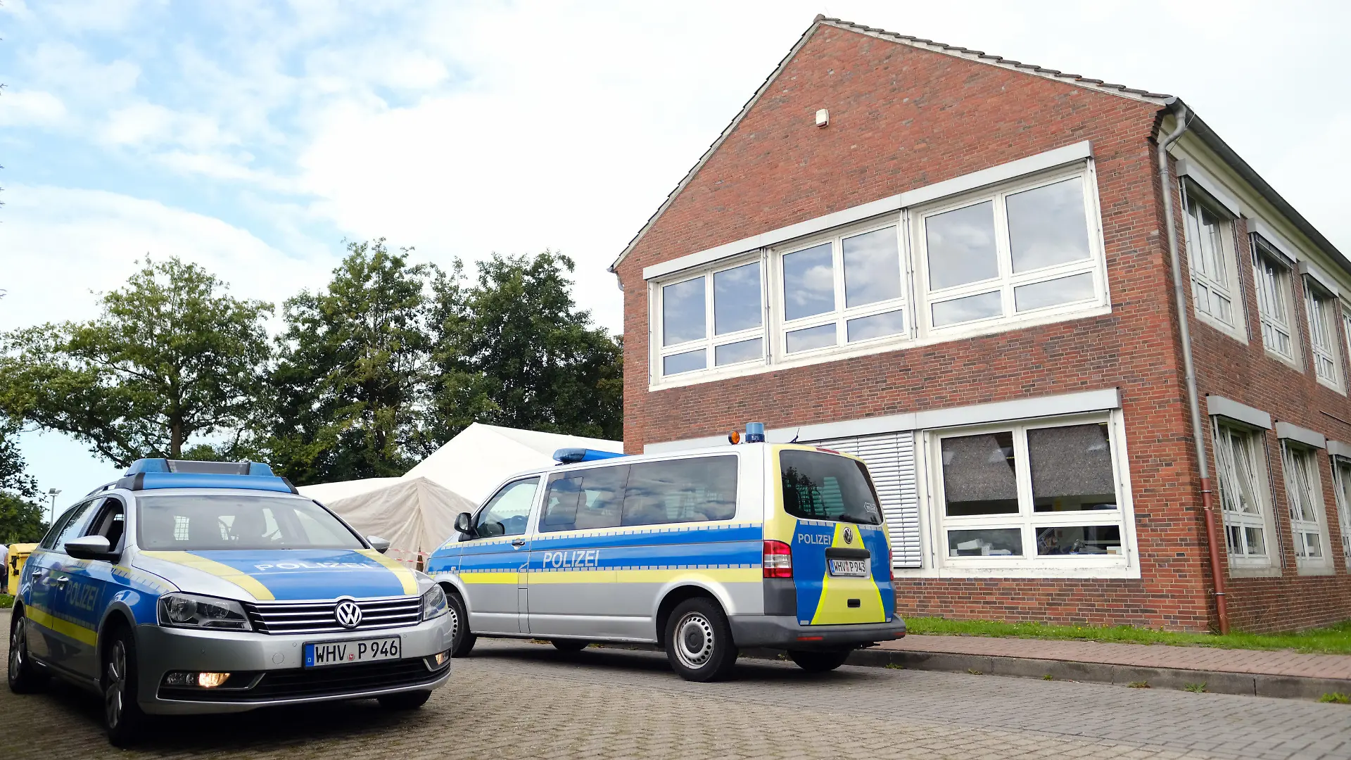 26.08.2021, Niedersachsen, Schortens: Polizeiwagen stehen vor dem Impfzentrum. In den Morgenstunden durchsuchten Beamte mehrere Gebäude des Deutschen Roten Kreuzes (DRK) in Friesland. Die Soko "Vakzin" hat bei ihren Ermittlungen weitere Unregelmäßigkeiten festgestellt.      (zu dpa "Durchsuchungen bei Ermittlungen zu Kochsalz-Injektionen") Foto: Markus Hibbeler/dpa +++ dpa-Bildfunk +++