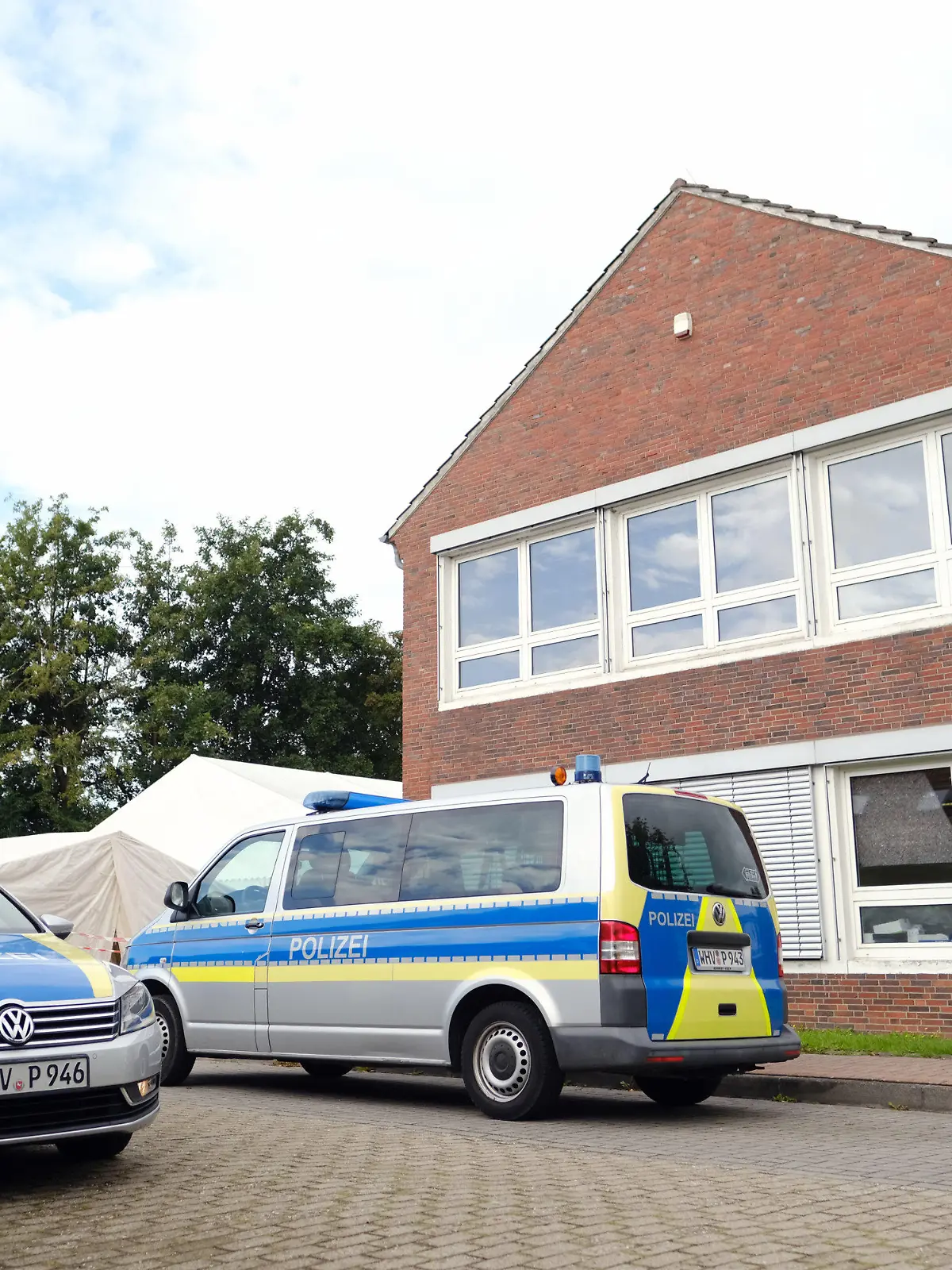 26.08.2021, Niedersachsen, Schortens: Polizeiwagen stehen vor dem Impfzentrum. In den Morgenstunden durchsuchten Beamte mehrere Gebäude des Deutschen Roten Kreuzes (DRK) in Friesland. Die Soko "Vakzin" hat bei ihren Ermittlungen weitere Unregelmäßigkeiten festgestellt.      (zu dpa "Durchsuchungen bei Ermittlungen zu Kochsalz-Injektionen") Foto: Markus Hibbeler/dpa +++ dpa-Bildfunk +++
