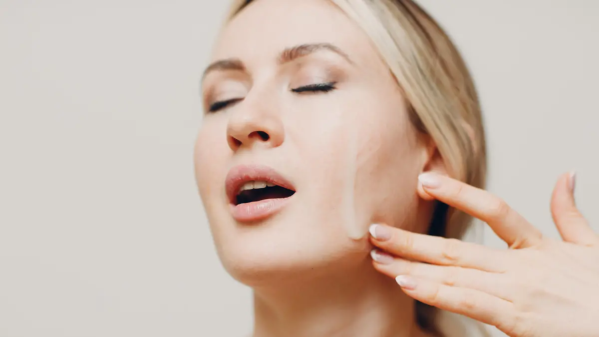 Cosmetic oil royal jelly applying with pipette on face of young woman