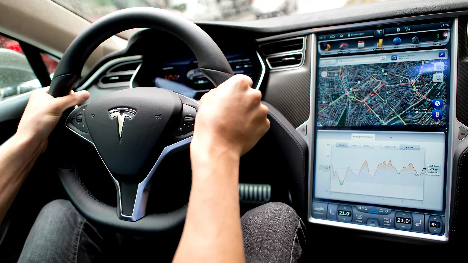ARCHIV - 17.08.2015, Bayern, München: Ein Mann sitzt in einem Tesla Model S am Lenkrad, neben ihm ein großer Monitor im Armaturenbrett.
(zu dpa "Behörde prüft Fehlfunktion von Tesla-Bildschirm") Foto: picture alliance / dpa +++ dpa-Bildfunk +++
