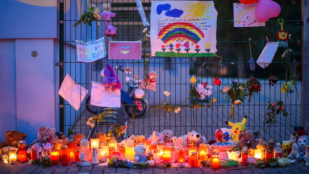 ARCHIV - 06.10.2020, Sachsen-Anhalt, Magdeburg: Kerzen, Blumen, Spielzeug und Kuscheltiere sind von anteilnehmenden Bürgerinnen und Bürgern vor dem Tor einer Kindertagesstätte abgelegt worden. Zuvor war am 2. Oktober 2020 ein Zweijähriger bei einem Ausflug mit seiner Kita-Gruppe in Magdeburg verschwunden und leblos in einem See gefunden worden worden. Am 19. August beginnt der Prozess gegen drei Erzieherinnen wegen fahrlässiger Tötung. (zu dpa: «Prozess gegen Erzieherinnen nach Ertrinkungstod eines Zweijährigen») Foto: Klaus-Dietmar Gabbert/dpa-Zentralbild/dpa +++ dpa-Bildfunk +++