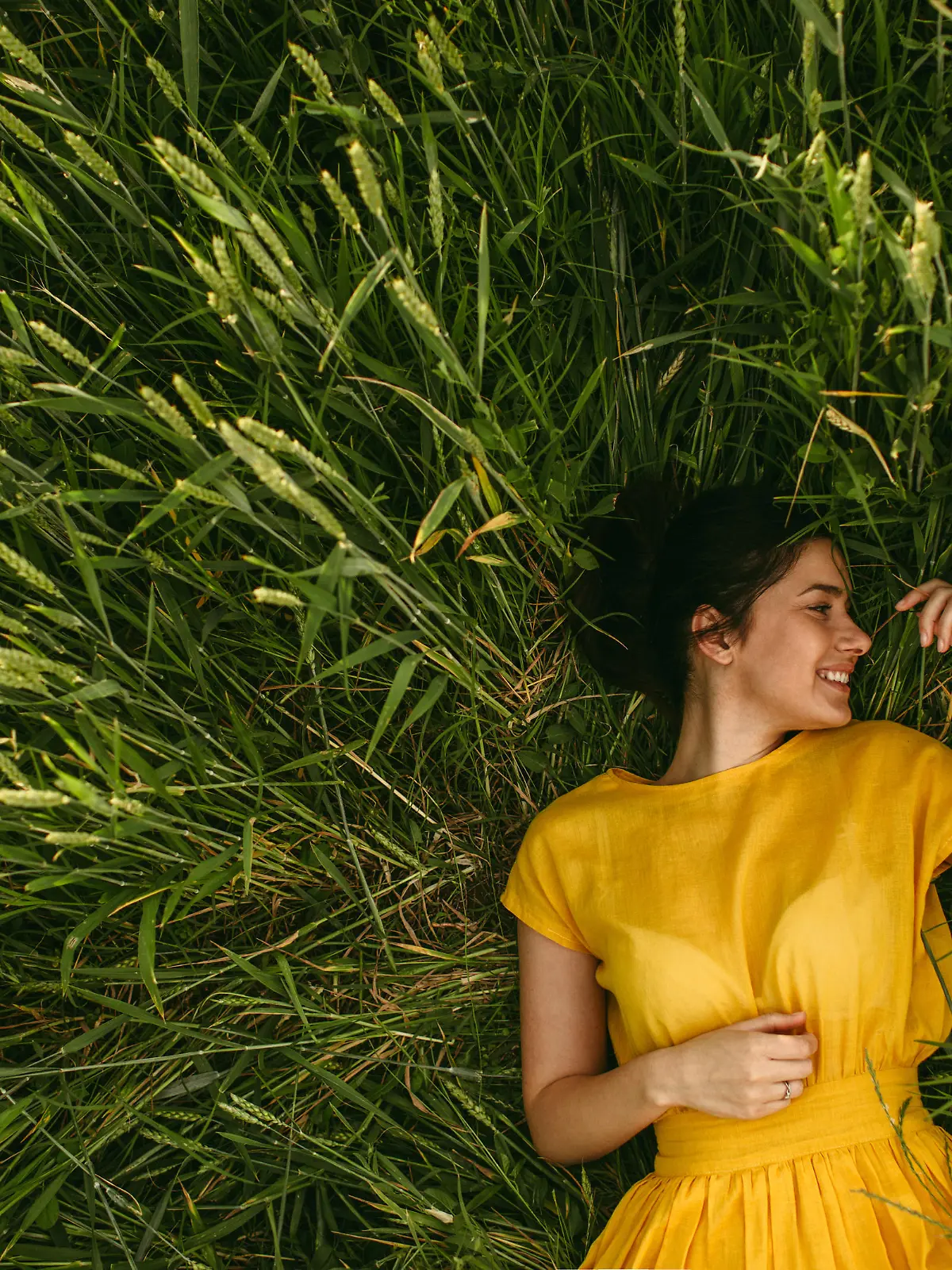 Young girl holding chamomile plant in her hands and enjoying the calm meadow