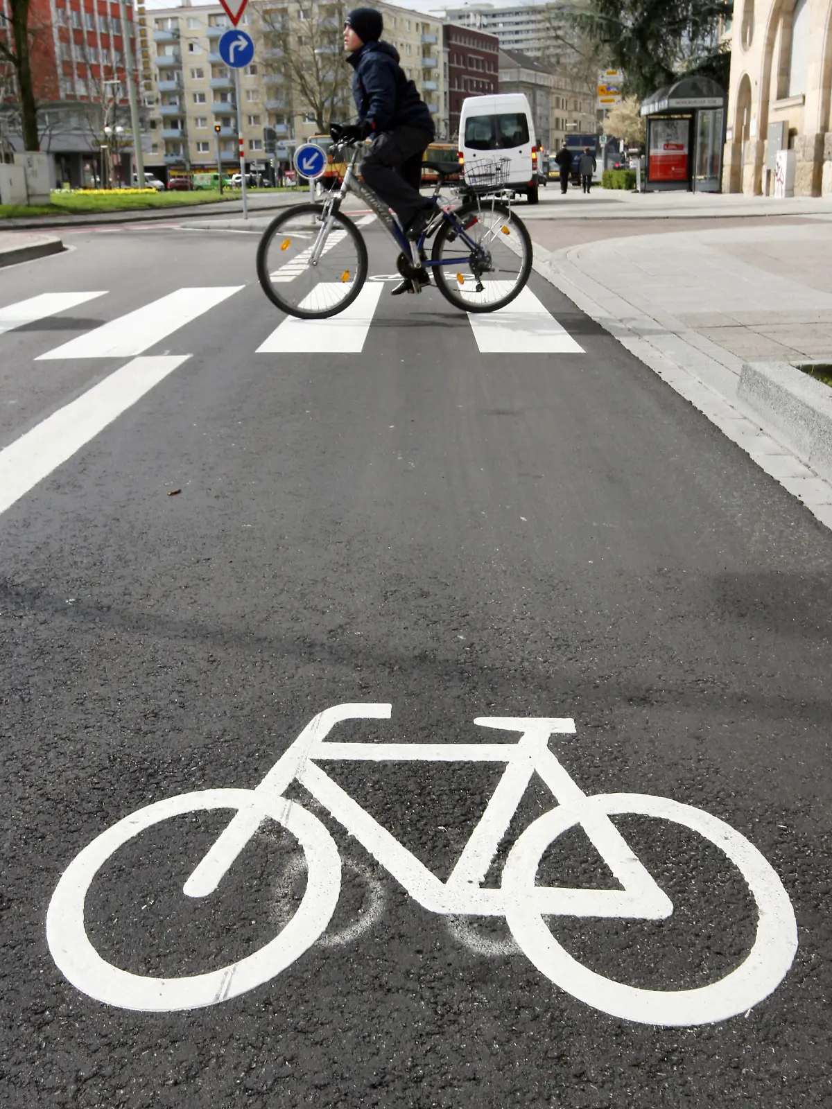 ARCHIV - Ein Radfahrer überquert in der Innenstadt von Karlsruhe einen Zebrastreifen, im Vordergrund ist ein großes Fahrradsymbol auf der Straße zu sehen (Archivfoto vom 25.03.2008). Der baden-württembergische Verkehrsminister Hermann möchte den Anteil des kommunalen Radverkehrs innerhalb von zehn Jahren zu verdoppeln. Mit der Initiative «RadKultur» will der der Verkehrsminister die Akzeptanz des Fahrradfahrens fördern.   Foto: Uli Deck dpa/lsw (zu lsw - Thema des Tages: «Grün-Rot will Radverkehr in zehn Jahren verdoppeln» vom 29.03.2012)  +++(c) dpa - Bildfunk+++