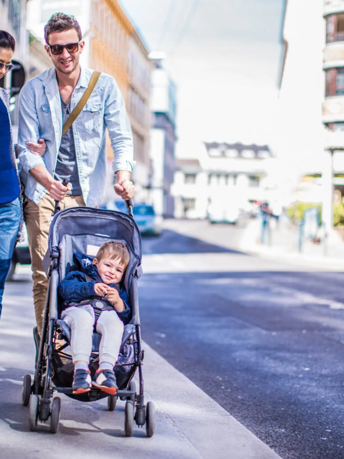 Photo of cool couple and their baby boy having a walk