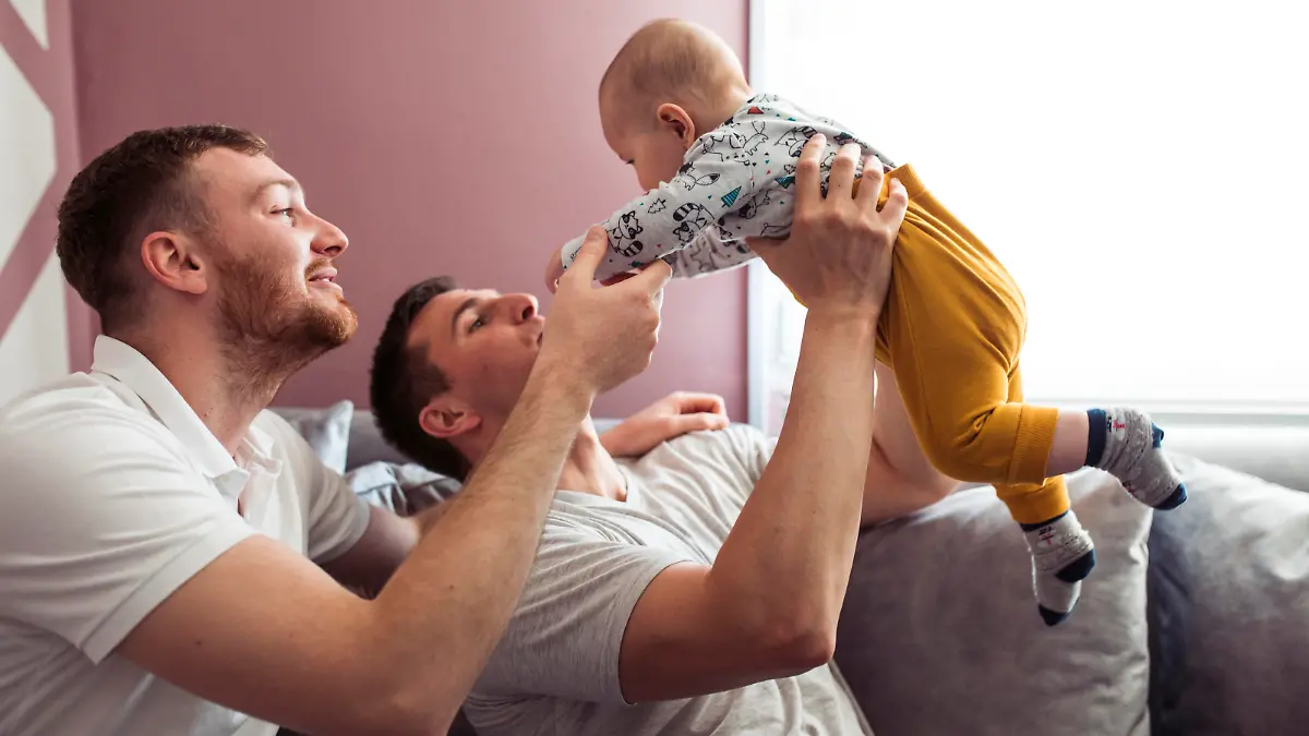 Homosexual couple is taking care of a little baby