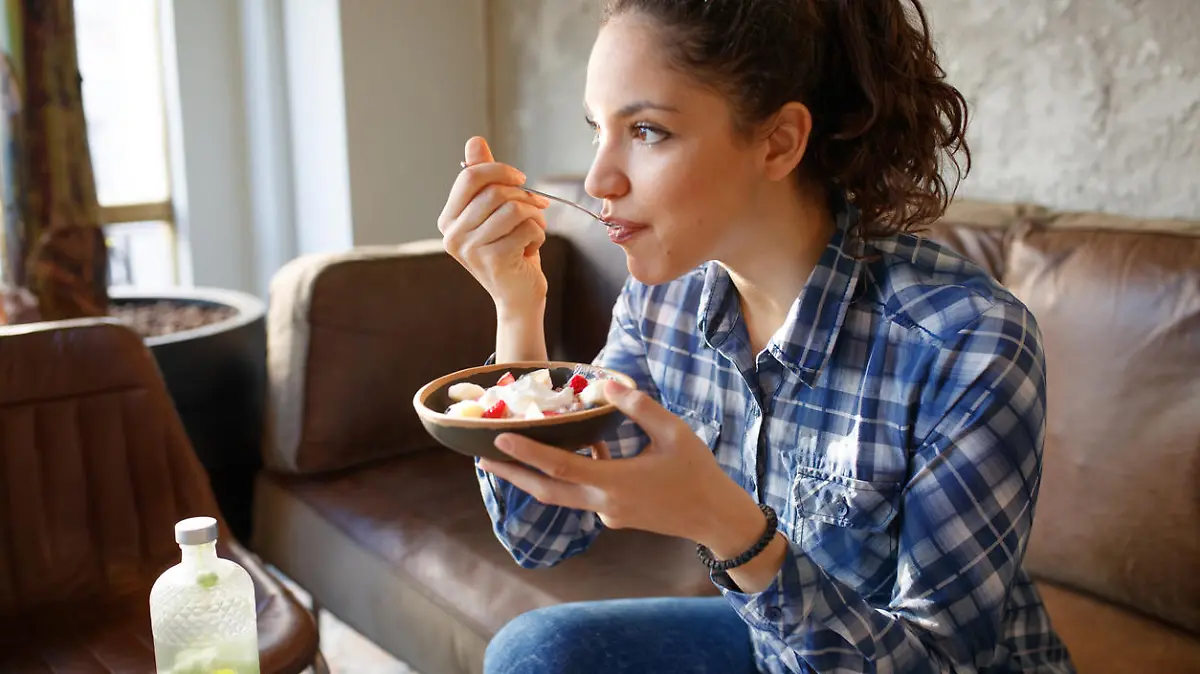 Woman eating cereals with yogurth