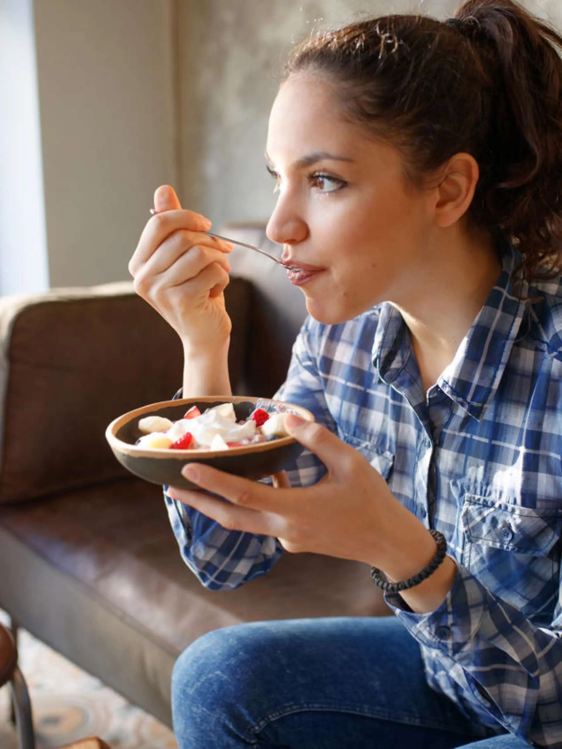 Woman eating cereals with yogurth