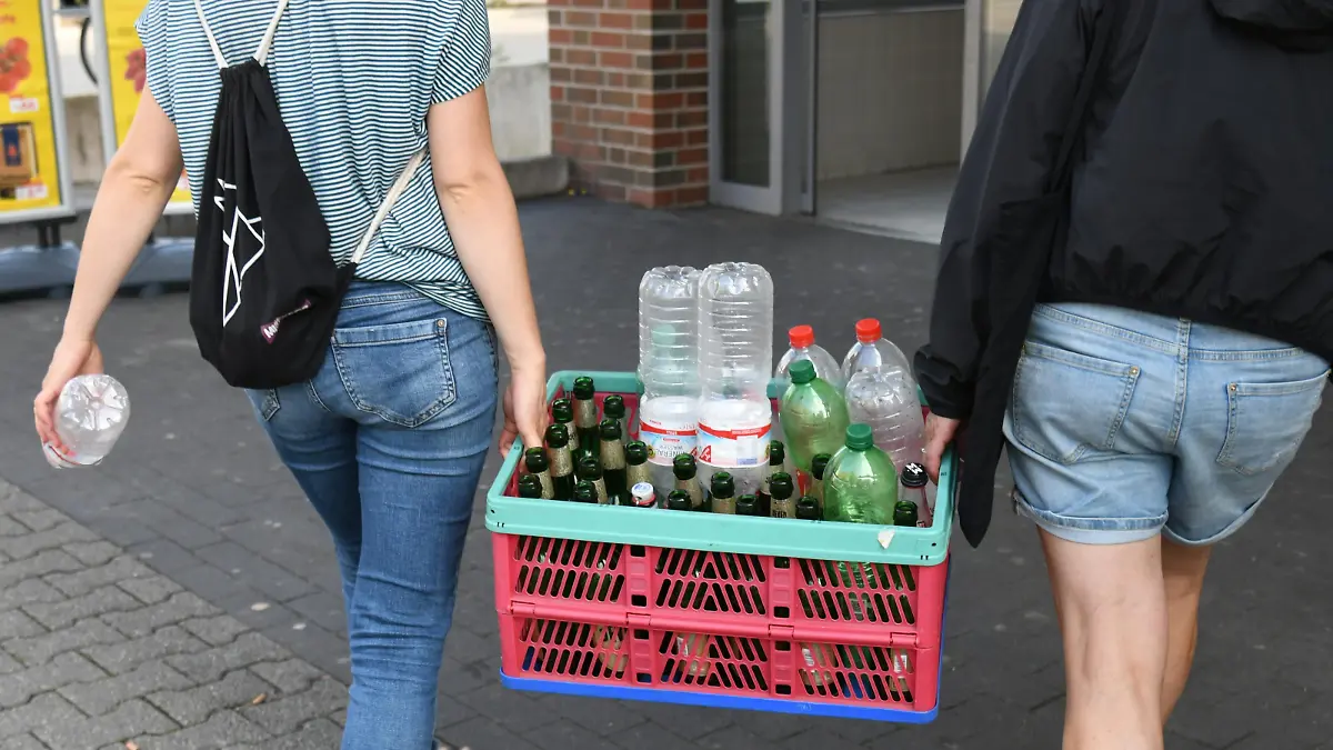 Zwei Frauen tragen eine Kiste mit Leergut in einen Supermarkt in Berlin, um die Pfandflaschen zurückzugeben. Foto: Winfried Rothermel