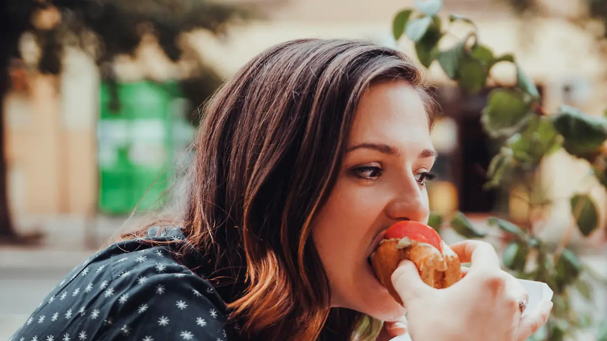 Young Woman Eating A Hotdog