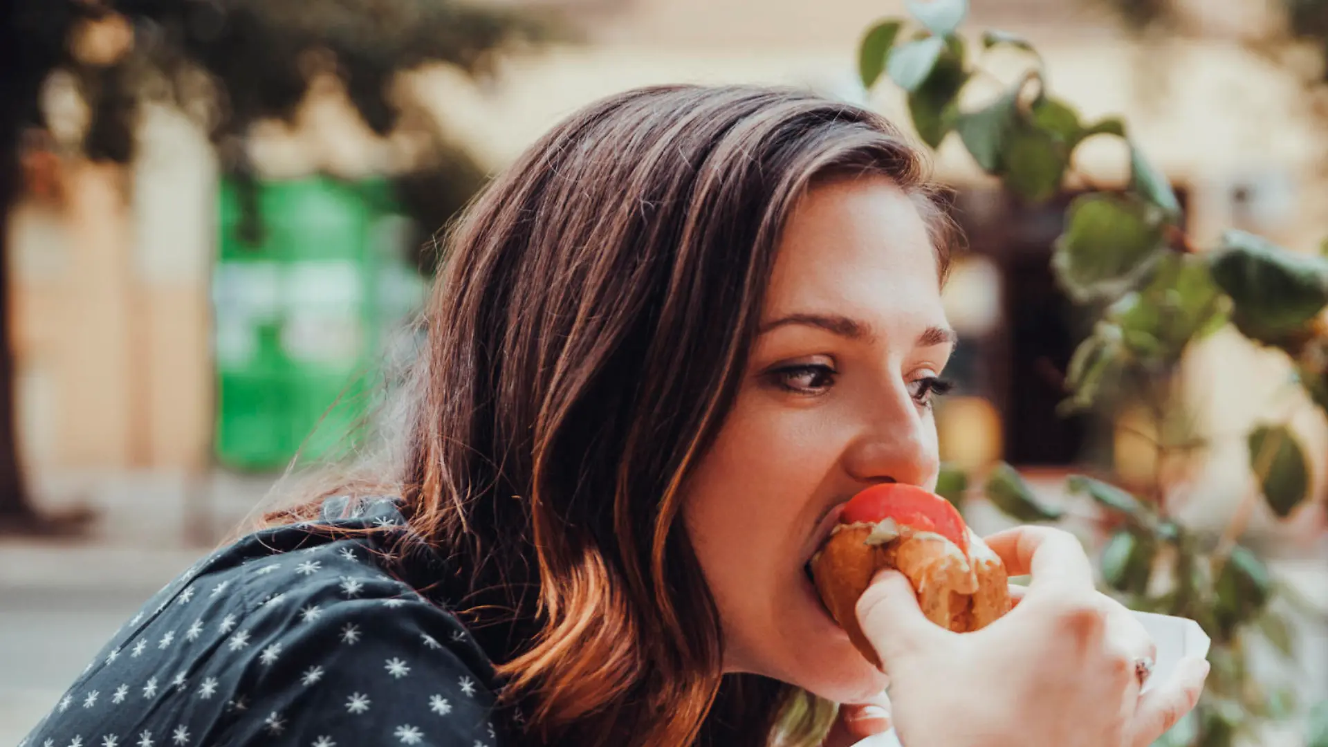 Young Woman Eating A Hotdog