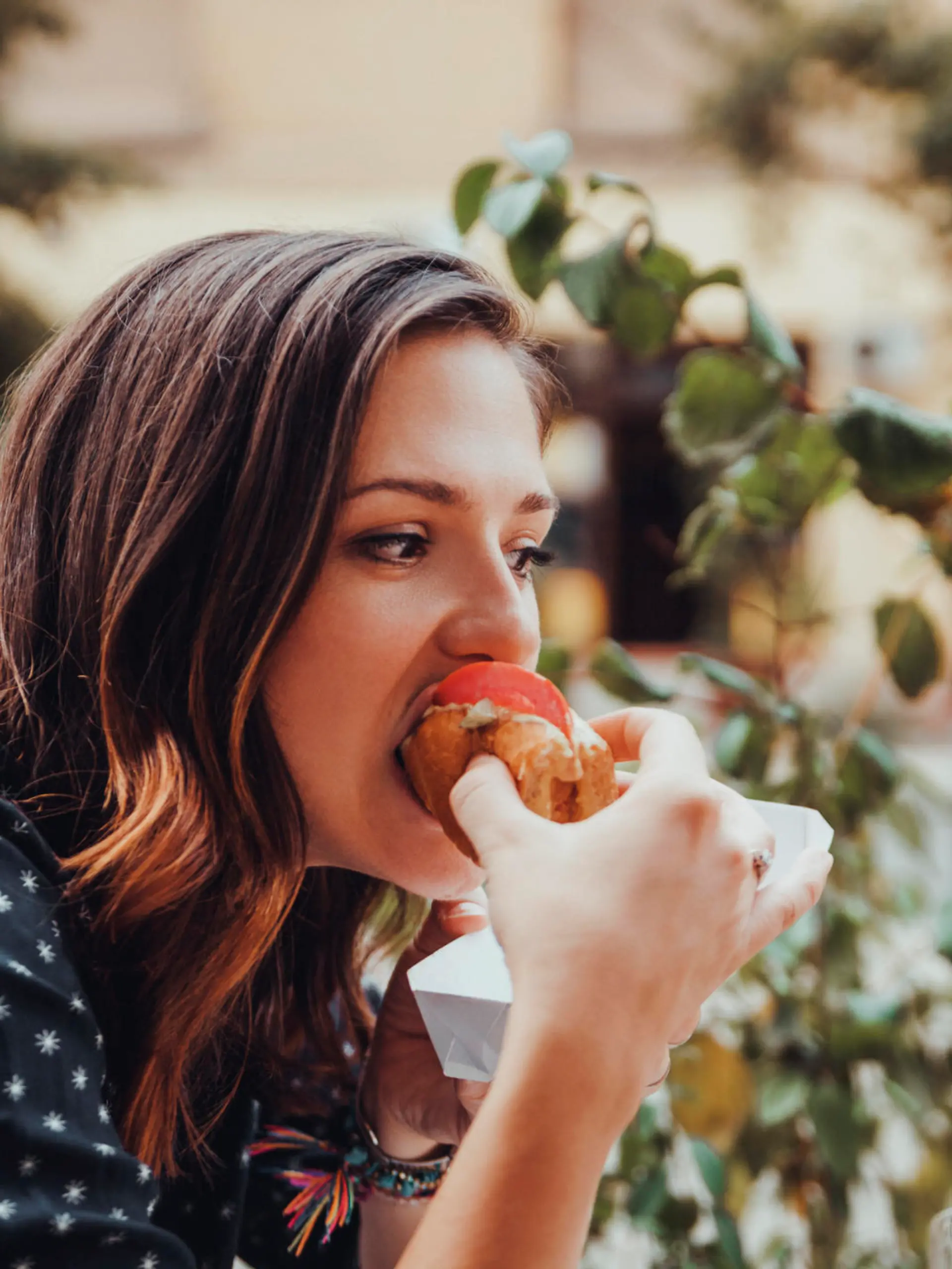 Young Woman Eating A Hotdog