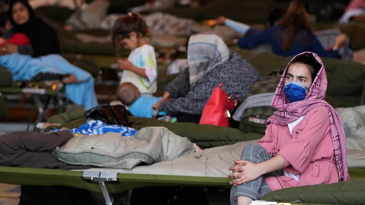A recently evacuated Afghan girl sits on a bench at the Ramstein U.S. Air Base, Germany, Tuesday, Aug. 24, 2021.The largest American military community overseas housed thousands Afghan evacuees in an increasingly crowded tent city. (AP Photo/Matthias Schrader)