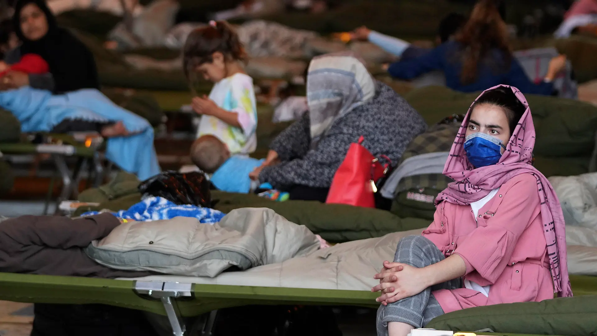 A recently evacuated Afghan girl sits on a bench at the Ramstein U.S. Air Base, Germany, Tuesday, Aug. 24, 2021.The largest American military community overseas housed thousands Afghan evacuees in an increasingly crowded tent city. (AP Photo/Matthias Schrader)